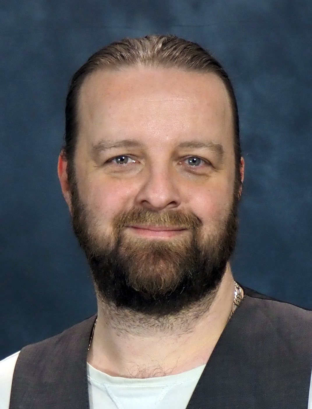 Jay Graham smiling, blue backdrop